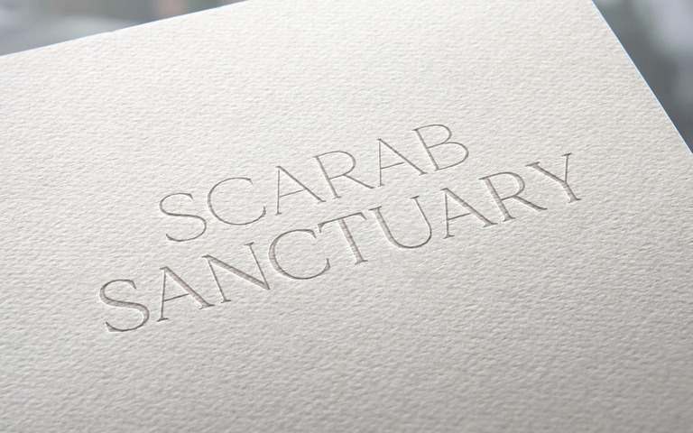 Geprägtes Scarab-Sanctuary-Logo auf strukturiertem Papier